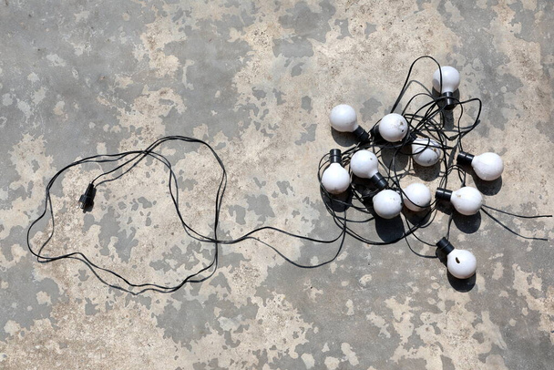 Old bulbs are arranged in different ways on the cement floor - Fotoğraf, Görsel
