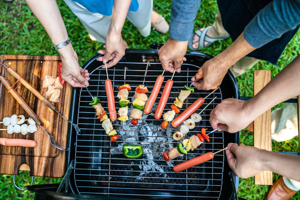 People hand grill BBQ in food party home garden happy friendship - Foto, Bild