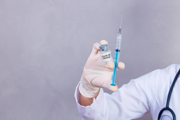 pielęgniarka posiadająca szczepionkę i strzykawkę z lekiem covid 19. Koronavac. Szczepienie przeciwko nowemu wirusowi Corona Vacine-Covid19: Strzykawka jest przygotowywana ze szczepionką Vacine-Covid 19. - Zdjęcie, obraz