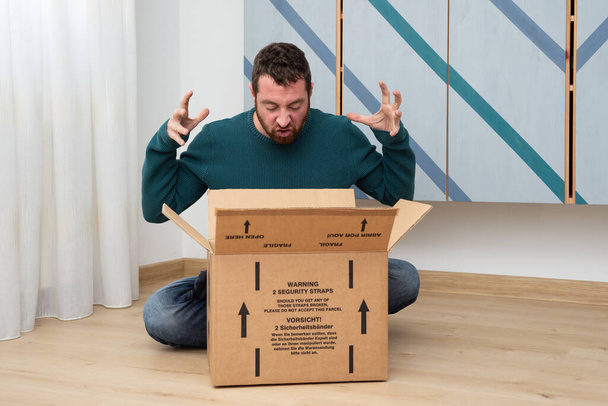 A caucasian man is really angry by received parcel. Bad delivery service concept. - Foto, Imagem