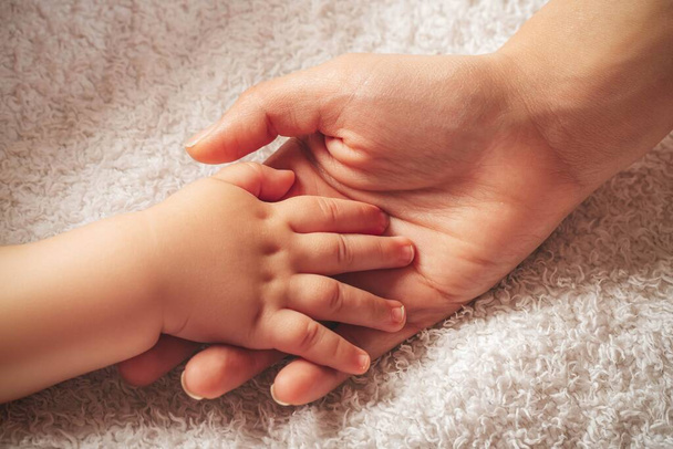 Kis gyermek keze van a kezében anyu - Fotó, kép