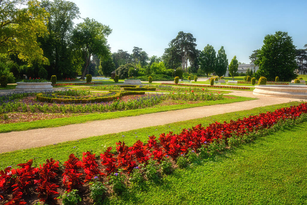 A Festetics Palota gyönyörű kertje virágokkal, zöld fűvel és fákkal egy napos nyári napon, Keszthely, Zala. Kültéri utazási háttér - Fotó, kép