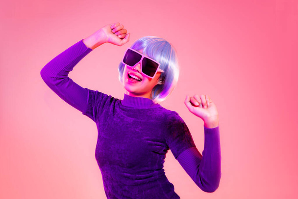 Cyber punk girl concept, happy asian woman in purple sweatshirt silver and blue short hair style wearing sunglasses posing like robot - Foto, Imagem