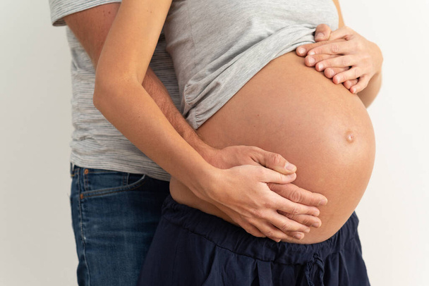 Άνδρας και γυναίκα ζευγάρι αγκαλιάζει την κοιλιά έγκυος.  - Φωτογραφία, εικόνα
