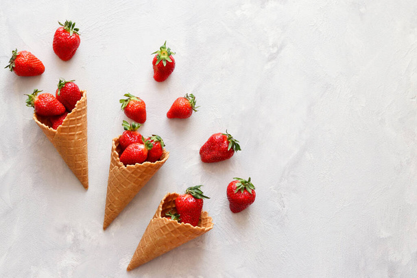 Fresh strawberries in waffle cones. Summertime mood. Flat lay, top view. - Fotografie, Obrázek