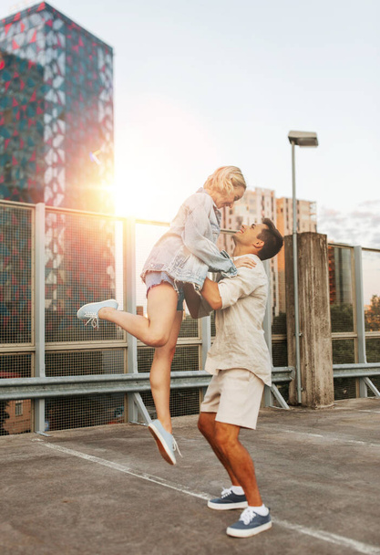 summer holidays, love and people concept - happy young couple on roof top city parking - Foto, afbeelding