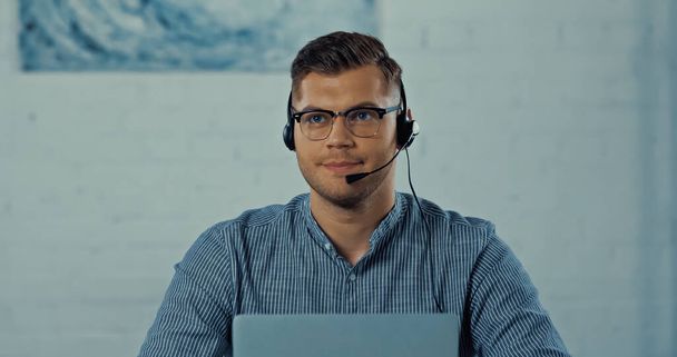 teletrabajador en auriculares con micrófono y gafas trabajando desde casa - Foto, Imagen