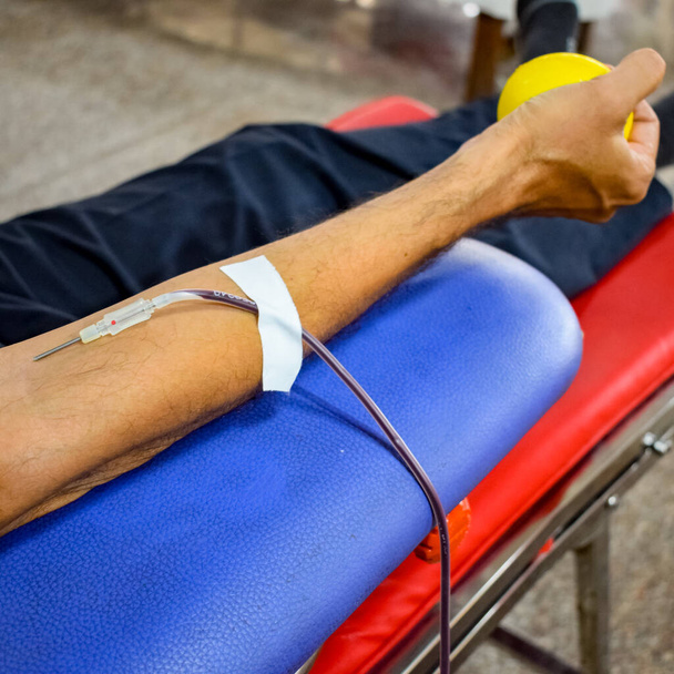 Dárce krve v dárcovském táboře se koná s skákacím míčem drží v ruce v chrámu Balaji, Vivek Vihar, Dillí, Indie, Obrázek pro Světový den dárců krve 14. června každého roku, Krevní darovací tábor - Fotografie, Obrázek