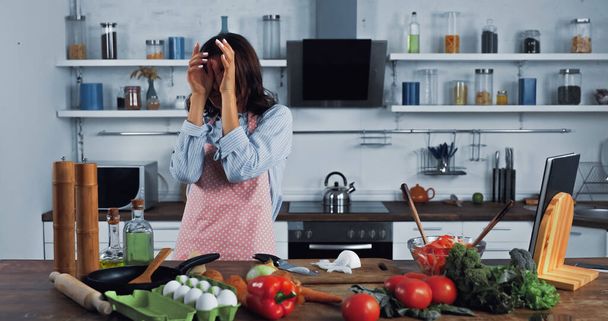 woman wiping irritated eyes near chopped onion on chopping board - 写真・画像