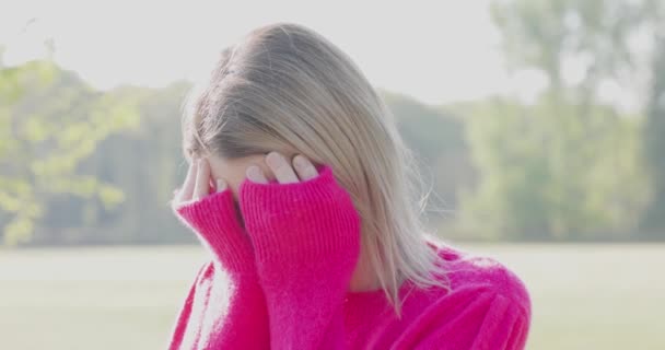 Müde, traurig oder deprimiert junge schöne blonde Frau vergräbt ihr Gesicht in ihren Händen vor Angst, mit Angstattacken oder Kopfschmerzen Migräne oder Depressionen, verärgert frustrierte Mädchen geplagt mit - Filmmaterial, Video