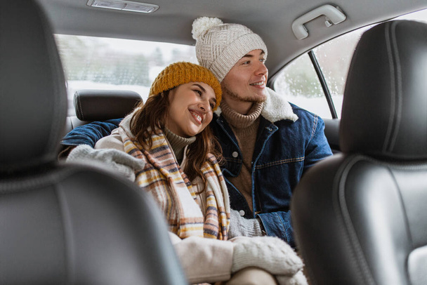 people, love and leisure concept - happy smiling couple hugging on car back seat in winter - Fotografie, Obrázek