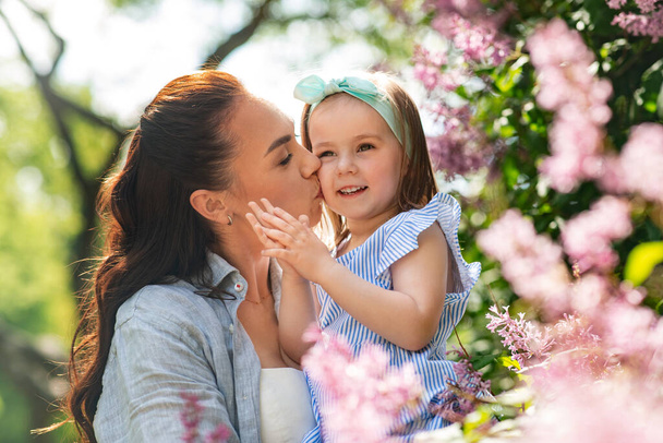 family, motherhood and people concept - happy mother with little daughter at summer park or garden - Foto, immagini