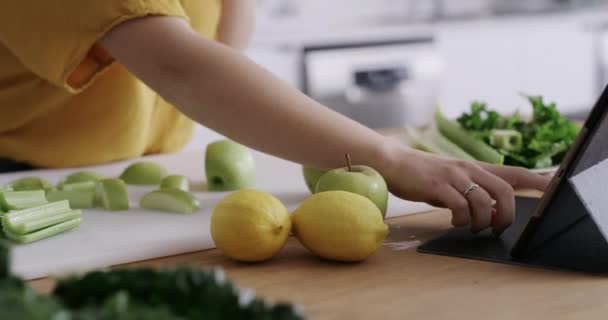 4k video footage of a young woman using a digital tablet and smartphone while preparing a healthy meal at home. - Video