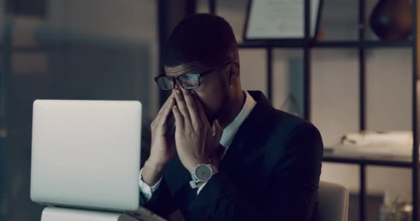 4k видеозапись молодого бизнесмена, выглядящего напряженным во время использования ноутбука во время поздней ночи на работе. - Кадры, видео