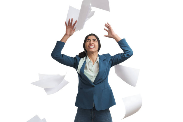 Young Venezuelan businesswoman stressed throwing paperwork. Isolated over white background. - Foto, imagen