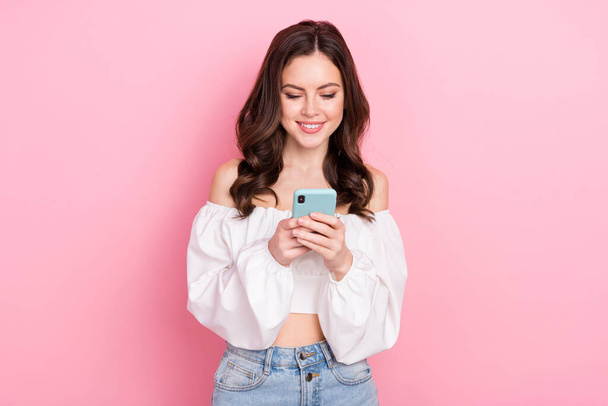 Photo of young stunning good mood blogger girl chatting with friends in smartphone isolated on pink color background. - Foto, Imagen