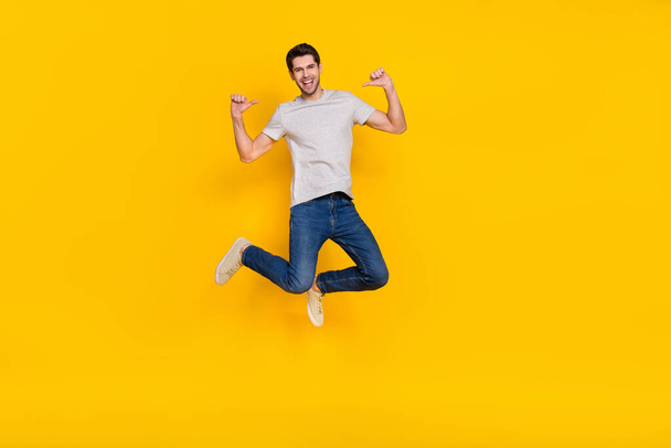 Full length body size view of attractive cheerful guy jumping demonstrating himself isolated over bright yellow color background. - Φωτογραφία, εικόνα