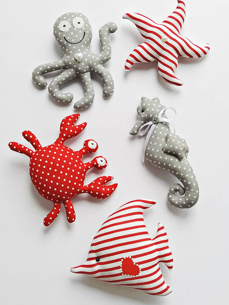 Handmade cartoon stuffed toys in hand, sea life octopus, crab, fish and seahorse. Toy crab, octopus, starfish, seahorse, and fish. DIY Flat lay - Foto, Bild