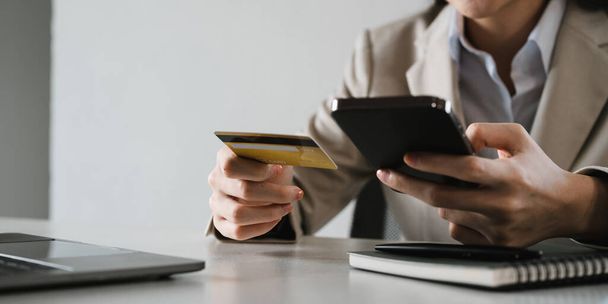 Close up female hands holding credit card and smartphone, young woman paying online, using banking service, entering information, shopping, ordering in internet store, doing secure payment. - Φωτογραφία, εικόνα
