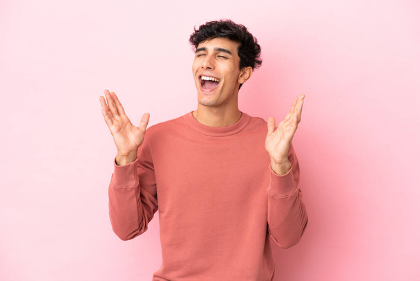 Young Argentinian man isolated on pink background smiling a lot - Zdjęcie, obraz