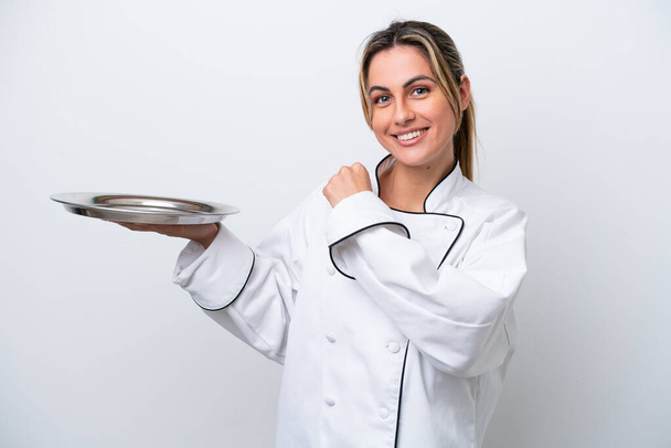 Jovem chef mulher com bandeja isolada no fundo branco comemorando uma vitória - Foto, Imagem