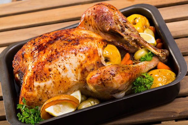 Rub on turkey with salt, pepper, provencal herbs, honey and balsamic. Cover with foil and cook in oven for 2 hours at 180 gramm. Then remove foil, put apples and vegetables and cook for 40 minutes - Фото, изображение