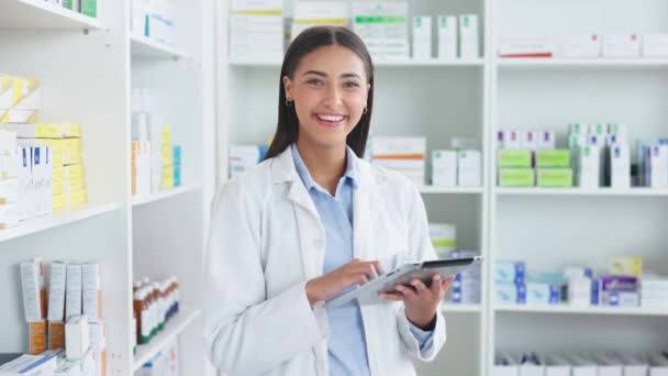 Portrait of pharmacist checking inventory or online orders using a digital tablet in a chemist. Young cheerful and friendly latino woman using a pharma app to do research on medication in a pharmacy. - Filmati, video