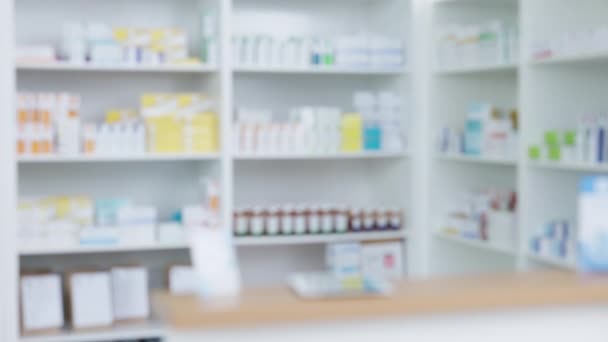 Blurred view of stocked pharmacy shelves in a chemist or hospital with copyspace. Pharmacy and healthcare industry background for treating patients. Prescription and over the counter service. - Filmati, video