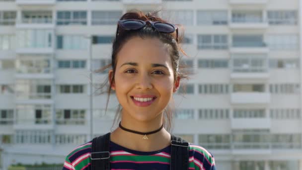 Portrait of confident fashionable woman showing cheerful facial expression in city. Smiling, young and hip student with backpack enjoying a day town. Trendy, cool and funky millennial standing alone. - Metraje, vídeo