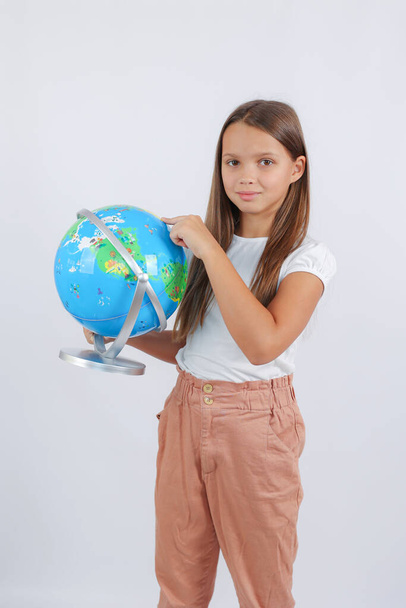girl with long hair standing pointing at the globe. High quality photo - Фото, зображення