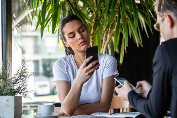 Mobilní koncept závislosti, přátelé ignorovat navzájem pomocí smartphonů relaxaci v kavárně, posedlý novými aplikacemi nebo sociálních sítí, telefonní závisláci ztracené v novinkách on-line - Fotografie, Obrázek