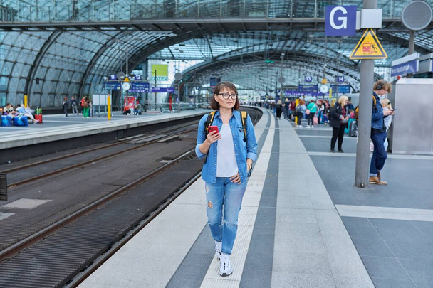 9.07.2022, Germany, Berlin Hauptbahnhof. Woman passenger walking along the platform of the railway station - Foto, Imagem