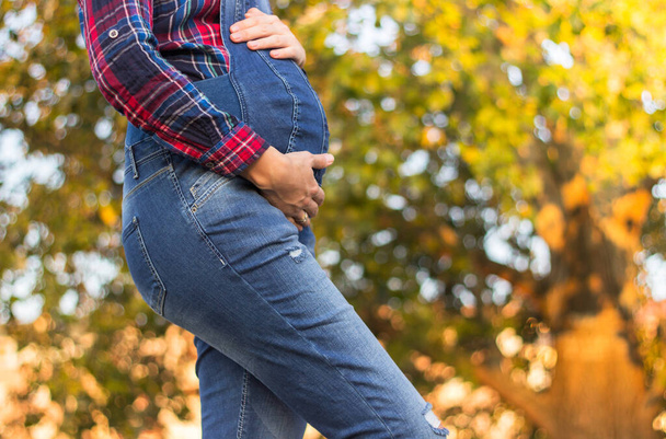 Красивая беременная женщина прикасается руками к животу
 - Фото, изображение