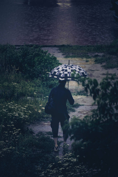 Man with umbrella walking rain wet path - Zdjęcie, obraz