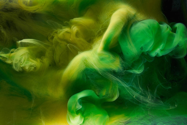Liquid fluid art abstract background. Green, yellow dancing acrylic paints underwater, space smoke ocean, color explosion - Foto, Imagen