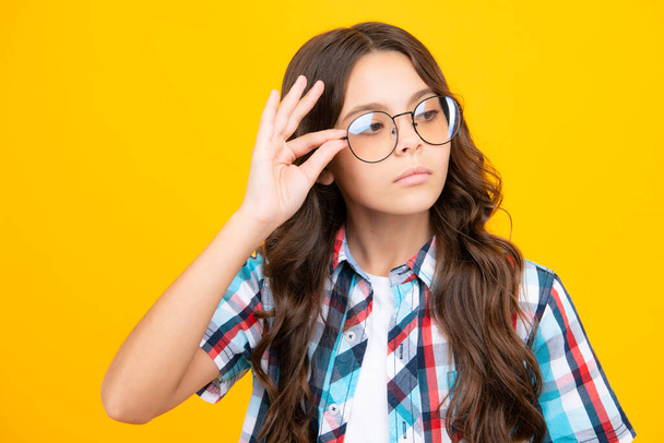 Teenager child with poor eyesight wear eyeglasses, looking squinting. Kids glasses. Funny surprised adorable girl in round glasses having astonished shocked facial expression - Photo, Image