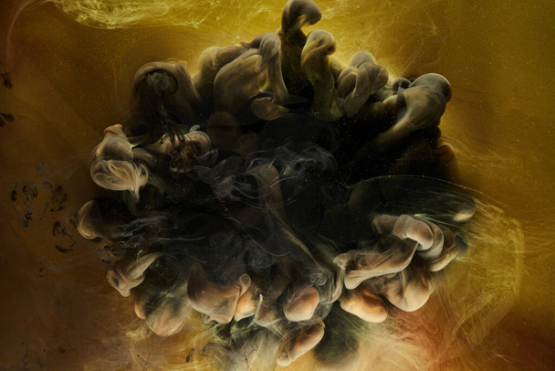 Liquid fluid art abstract background. Black, yellow dancing acrylic paints underwater, space smoke ocean - Foto, immagini