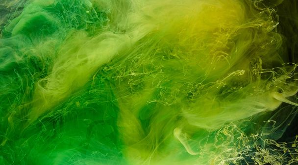 Liquid fluid art abstract background. Green, yellow dancing acrylic paints underwater, space smoke ocean, color explosion - Фото, изображение