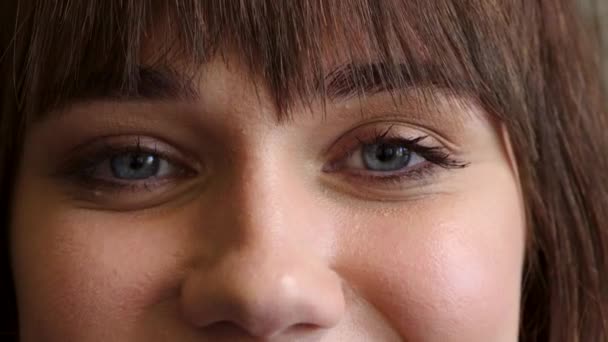 Close-up portret van apotheker met blauwe ogen kijken vooruit met zorgzame, vriendelijke en vriendelijke gezichtsuitdrukking. Gelukkige en zoete medische professional die luistert en vertrouwen toont aan patiënten of klanten. - Video