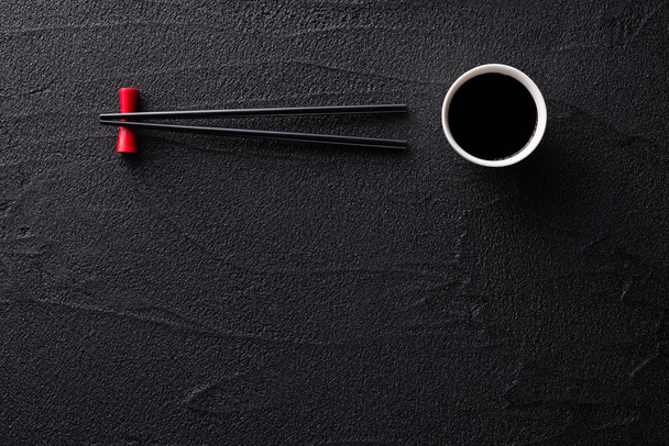 Палички та миска з соєвим соусом на чорному камені
 - Фото, зображення