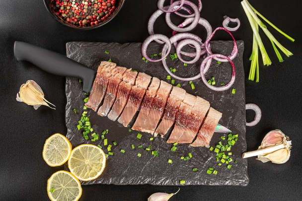 Fillet of lightly salted herring with spices, onion, garlic and  - 写真・画像