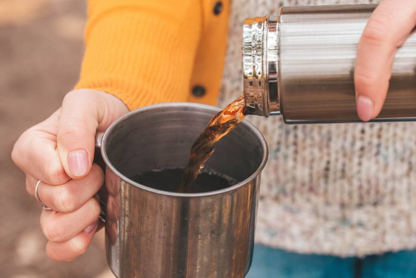 Close-up, pouring tea from a thermos into a mug - Fotó, kép