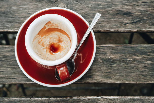 Großaufnahme einer leeren Tasse Kaffee auf dem Holztisch. Reste von Kaffeefleck nach dem Trinken. - Foto, Bild