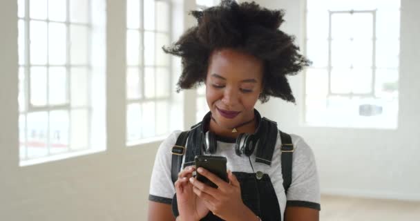 Hymyilevä nainen afro kutoma puhelimessa ja liittymällä dating sovellus. Yhteydenpito ja verkostoituminen ystävien kanssa sosiaalisessa mediassa tai pelien pelaaminen teknologiassa. Hymyilevä ärtyisä nainen lähettää flirttaileva tekstiviestejä. - Materiaali, video