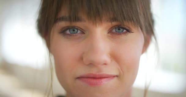 Portrait of a beautiful young woman with blue eyes smiling at the camera. Closeup on face of confident and carefree caucasian female feeling happy and optimistic in a good mood with positive attitude. - Metraje, vídeo