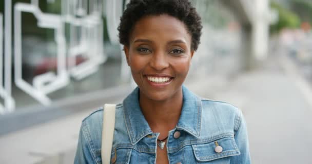 Portrait of a young beautiful woman having fun in city on the weekend. One smiling black female with an afro enjoying a day in town. Gorgeous woman showing her teeth and taking care of dental hygiene. - 映像、動画