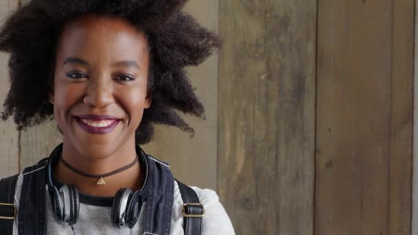 Leerling met een positieve houding glimlachend van vreugde. Portret van een moderne zwarte vrouw die lacht met copyspace. Trendy en edgy jonge Afrikaanse vrouw met stijlvolle afro op zoek vrolijk, koel en zelfverzekerd. - Video