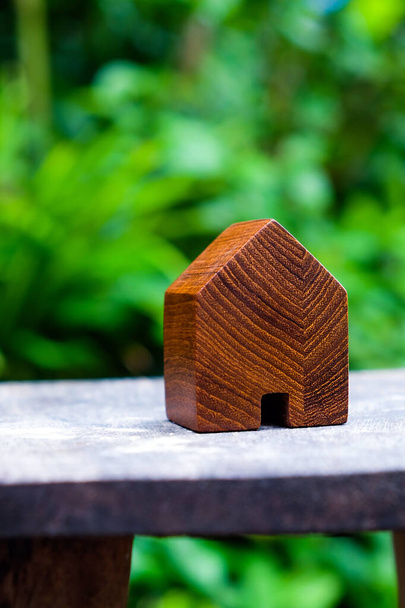 wood house model on wood table with green nature background , eco house icon concept. - 写真・画像