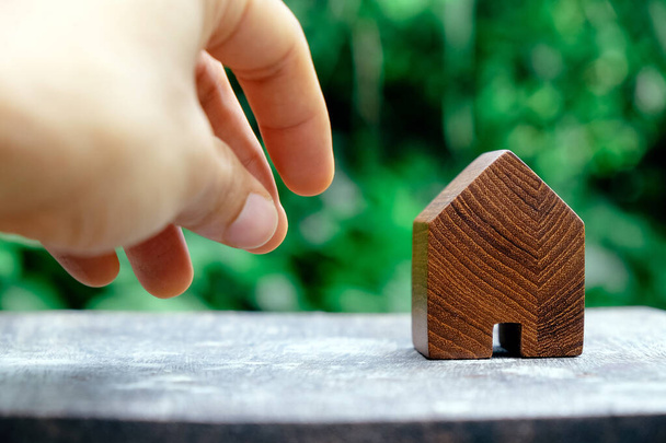 ξύλινο σπίτι μοντέλο σε ξύλινο τραπέζι με πράσινο φόντο φύση, eco house εικονίδιο έννοια. - Φωτογραφία, εικόνα
