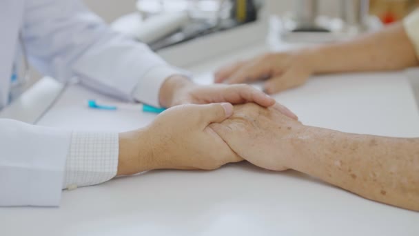 Hand of doctor comforting patient at consulting room. Doctor and patient are discussing consultation about symptom problem diagnosis of disease - Footage, Video